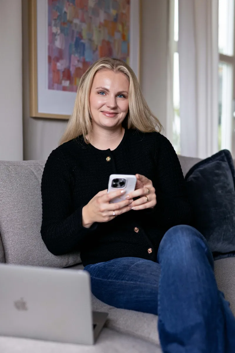 Ansatt i Meraki Marketing med mobil i sofaen
