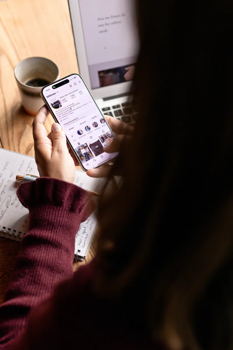 Ansatt ser på sosiale medier på mobilen