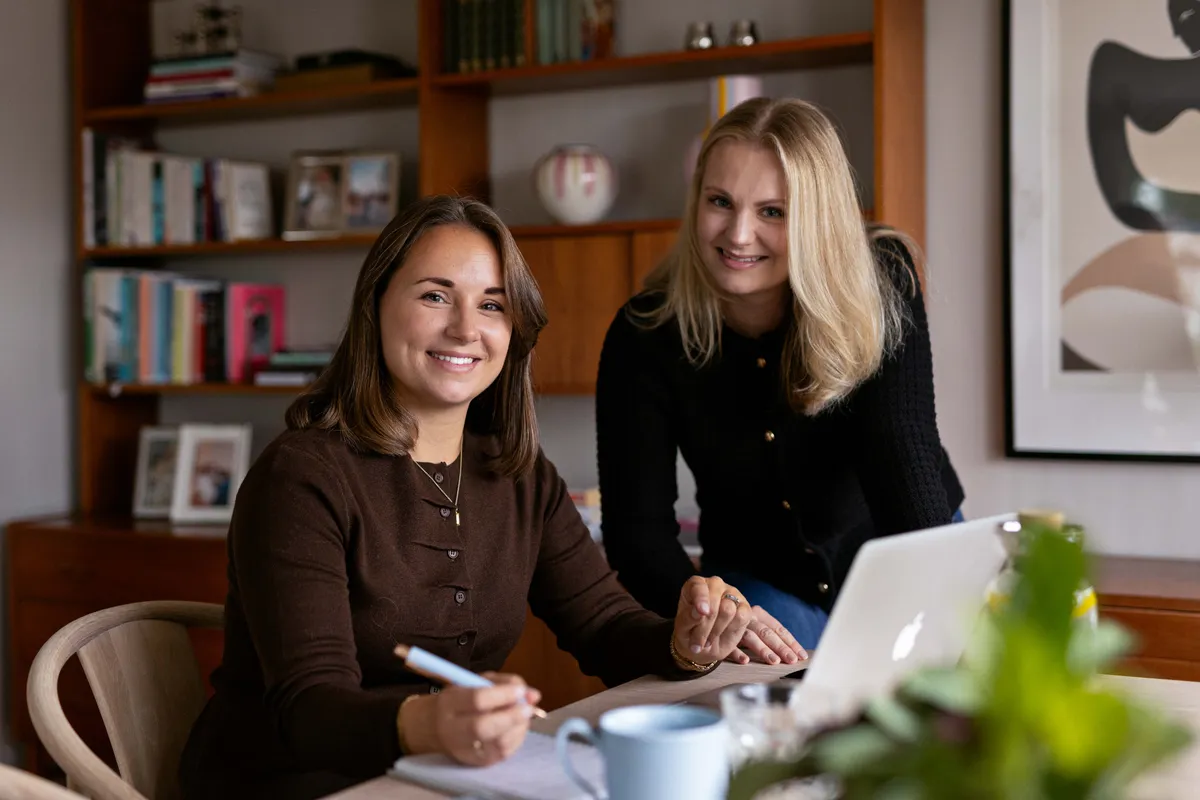 To ansatte i Meraki Marketing samarbeider over en laptop, Oslo