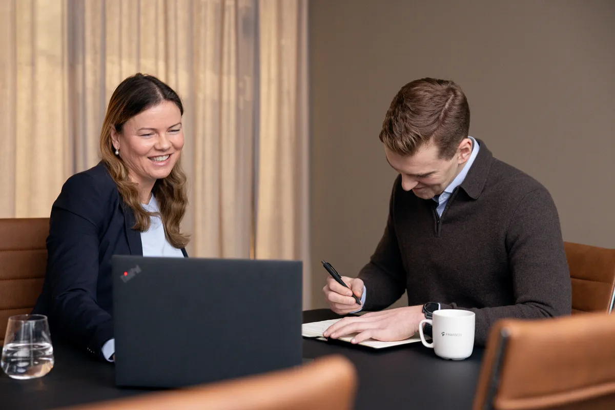 Kvinne og mann jobber konsentrert med laptoper ved bordet